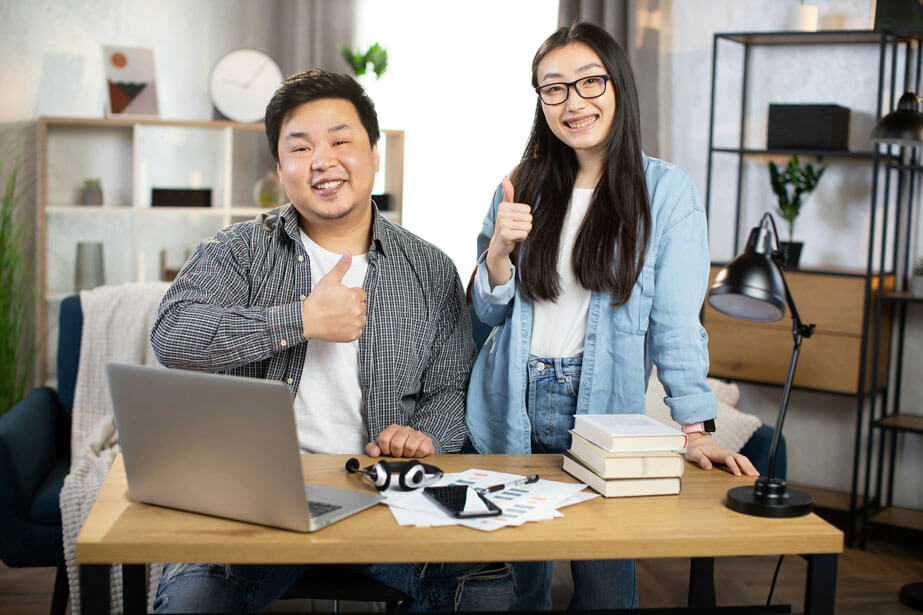 two people giving the thumbs up and smiling